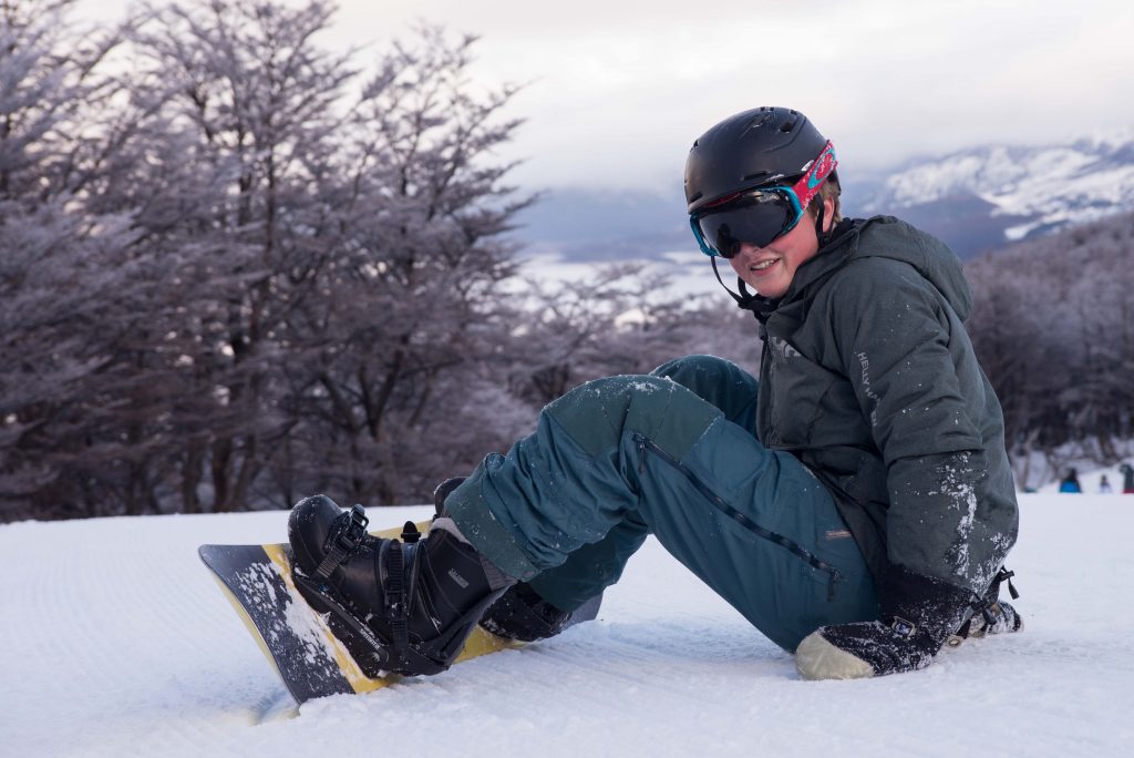 Learning to snowboard requires tons of time on the snow. Charlie H. takes a break on the snow at Cerro Castor.